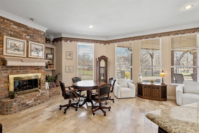 dining room with a brick fireplace and crown molding