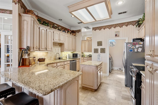 kitchen featuring crown molding, stainless steel appliances, visible vents, a sink, and a peninsula