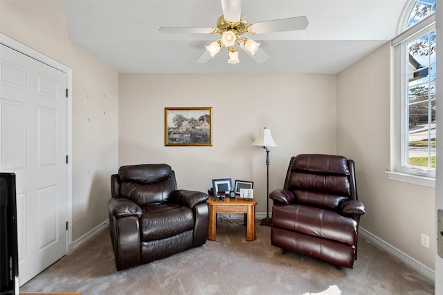 sitting room featuring carpet, baseboards, and ceiling fan