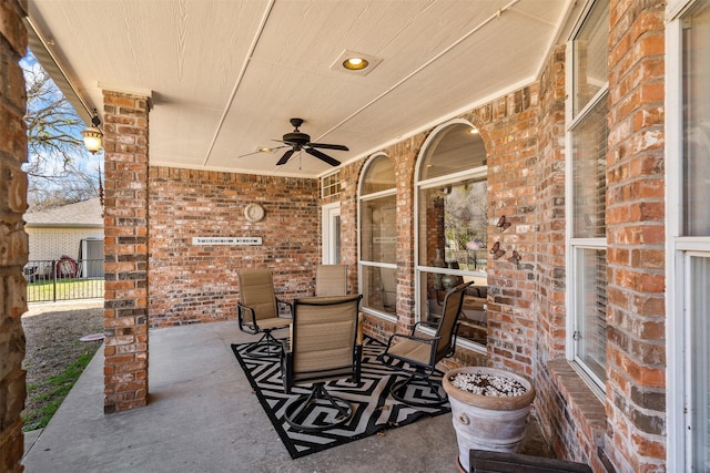 view of patio with ceiling fan, outdoor dining area, and fence