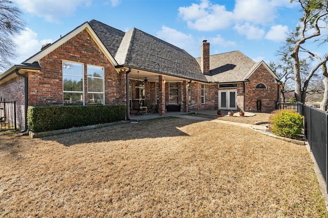 back of house with ceiling fan, a chimney, fence, french doors, and brick siding