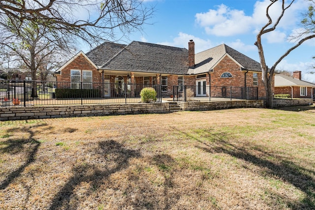 rear view of property featuring a patio area, brick siding, fence, and a lawn