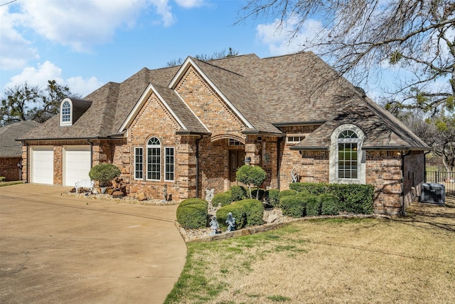 view of front of property with a garage, roof with shingles, concrete driveway, and brick siding