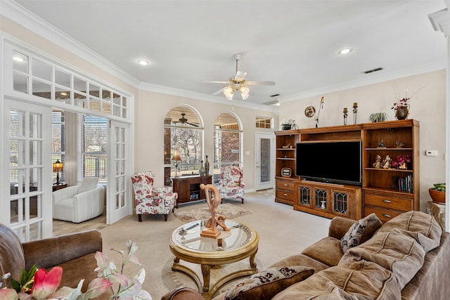 living area with visible vents, french doors, light colored carpet, and crown molding