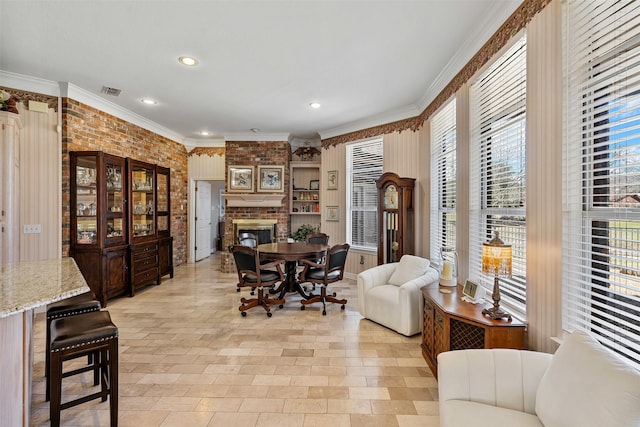 dining area featuring recessed lighting, visible vents, ornamental molding, a brick fireplace, and brick wall