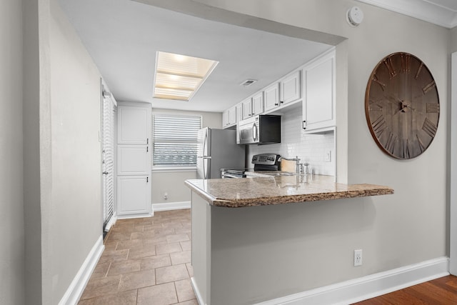 kitchen featuring tasteful backsplash, baseboards, white cabinets, appliances with stainless steel finishes, and a peninsula