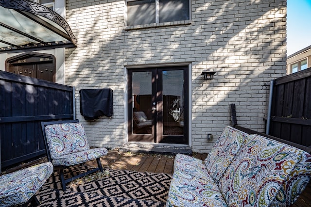 view of exterior entry with brick siding and fence