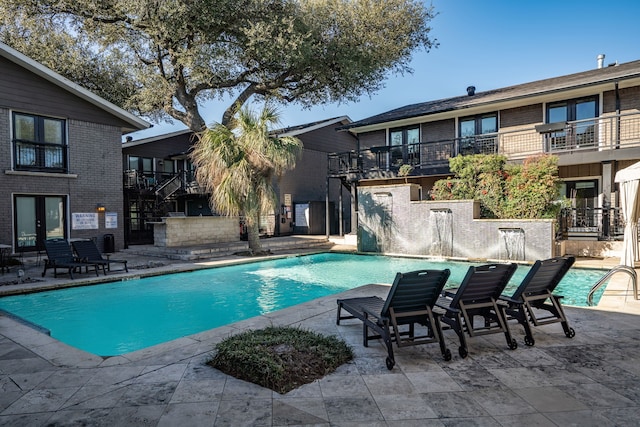 community pool featuring french doors, a patio, and stairs