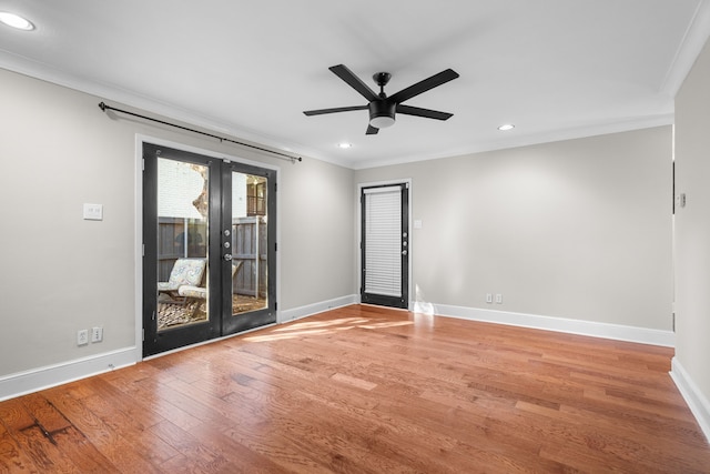 spare room featuring baseboards, french doors, wood finished floors, and crown molding