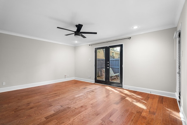 spare room featuring french doors, crown molding, light wood-style flooring, ceiling fan, and baseboards