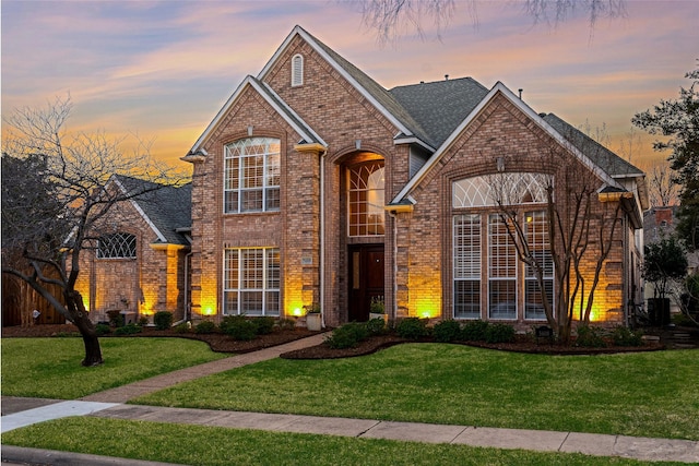 traditional home featuring brick siding and a front lawn