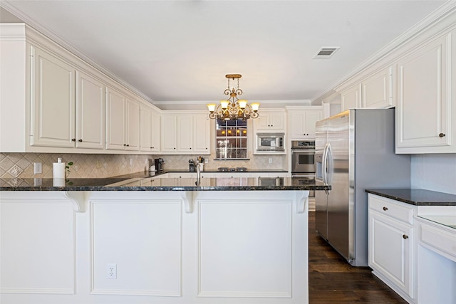 kitchen with visible vents, appliances with stainless steel finishes, a breakfast bar, and dark wood-type flooring