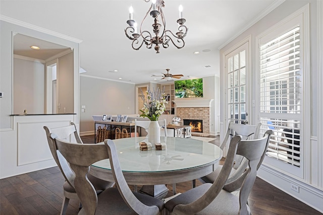 dining room featuring crown molding, recessed lighting, wood-type flooring, a brick fireplace, and ceiling fan with notable chandelier