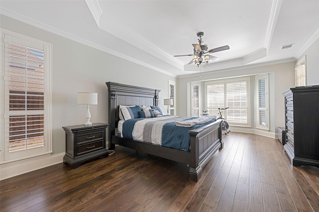 bedroom with visible vents, a raised ceiling, dark wood-type flooring, and ornamental molding