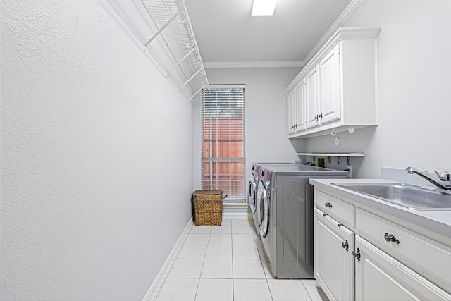 laundry area featuring crown molding, light tile patterned floors, cabinet space, a sink, and washer and dryer