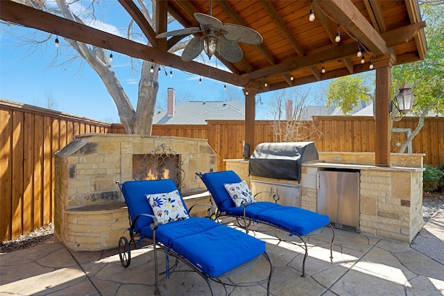 view of patio / terrace featuring a gazebo, area for grilling, a ceiling fan, exterior kitchen, and a fenced backyard