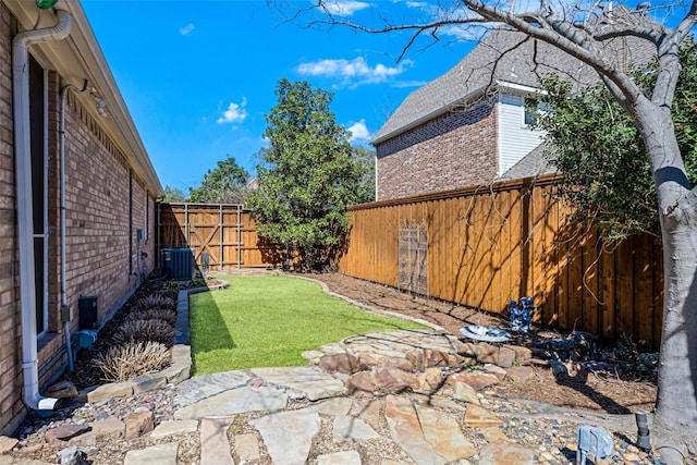 view of yard featuring a fenced backyard and central air condition unit