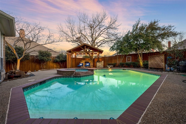 view of swimming pool featuring a patio area, a fenced backyard, a pool with connected hot tub, and a gazebo