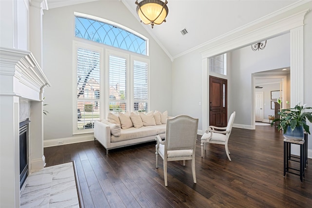 living area with high vaulted ceiling, a premium fireplace, visible vents, ornamental molding, and dark wood-style floors