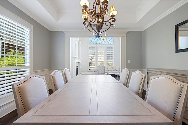 dining space featuring plenty of natural light, a tray ceiling, and a notable chandelier