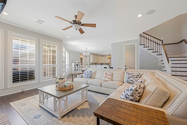 living area featuring recessed lighting, visible vents, wood finished floors, stairs, and ceiling fan with notable chandelier