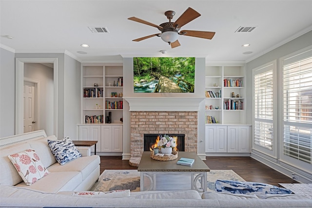 living room with ornamental molding, dark wood-type flooring, a fireplace, and built in shelves