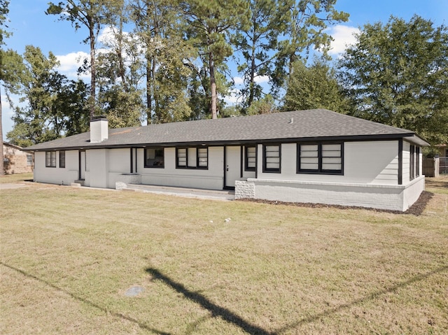 view of front facade featuring a chimney, a front lawn, and roof with shingles