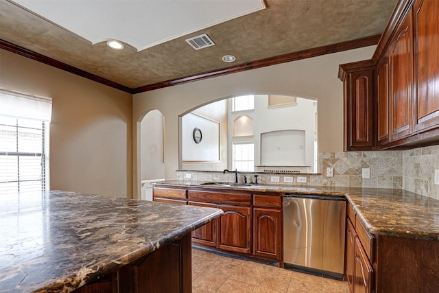 kitchen featuring dishwasher, a sink, visible vents, and decorative backsplash