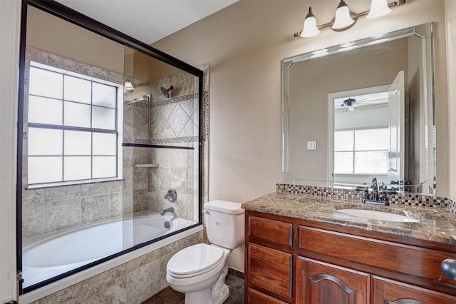 bathroom featuring ceiling fan, tiled shower / bath, toilet, and vanity