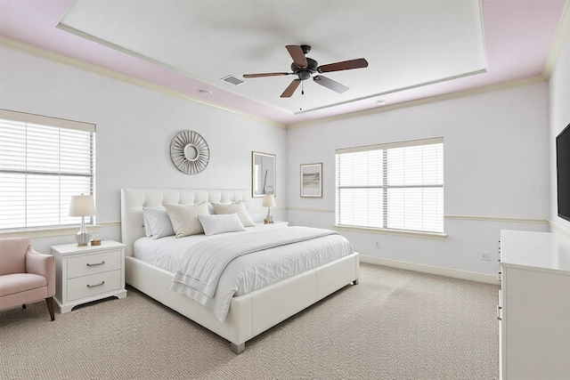 bedroom featuring baseboards, a tray ceiling, visible vents, and light colored carpet