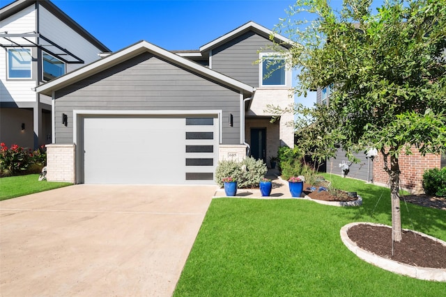 view of front of property featuring an attached garage, driveway, brick siding, and a front yard