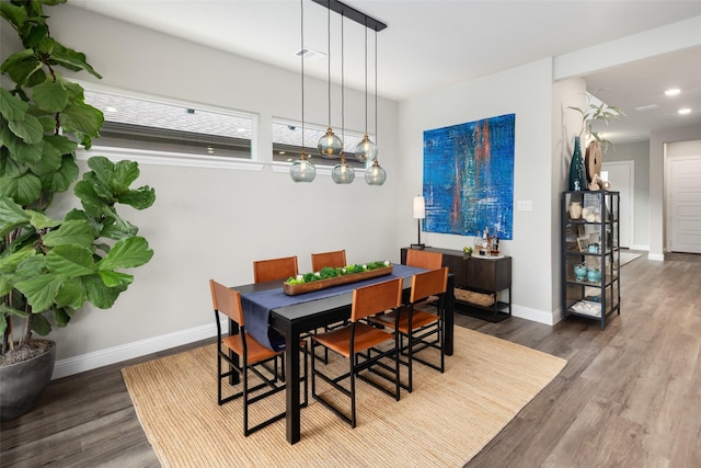 dining area featuring baseboards, wood finished floors, and recessed lighting