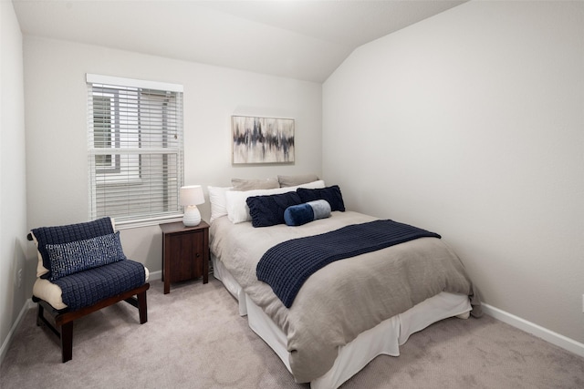 bedroom featuring lofted ceiling, light carpet, and baseboards