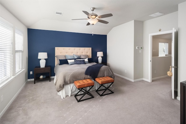 carpeted bedroom featuring lofted ceiling, ceiling fan, visible vents, and baseboards