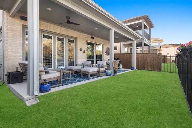 rear view of house with french doors, brick siding, a yard, fence, and ceiling fan