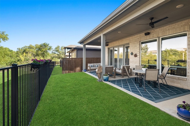 view of yard with ceiling fan, outdoor lounge area, fence, french doors, and a patio area