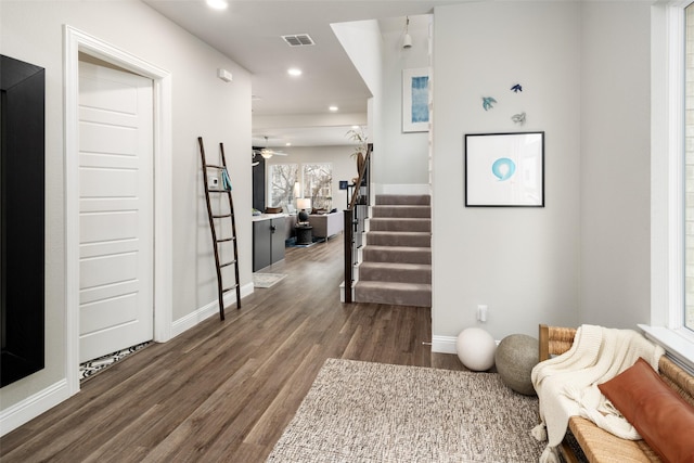 interior space with recessed lighting, visible vents, dark wood-type flooring, baseboards, and stairs