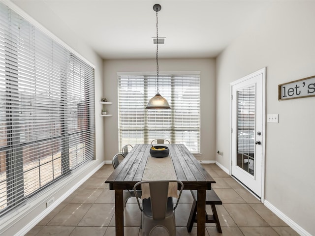 tiled dining room with baseboards and visible vents