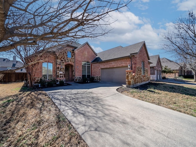 view of front facade featuring a garage, driveway, fence, and brick siding