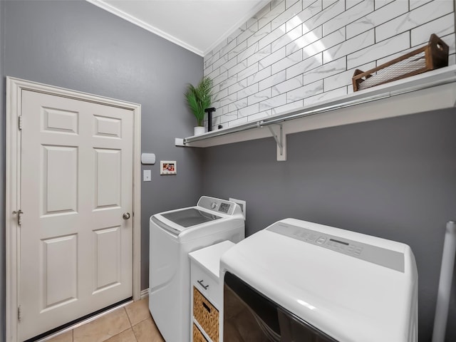 laundry room featuring laundry area, ornamental molding, light tile patterned flooring, and washing machine and clothes dryer