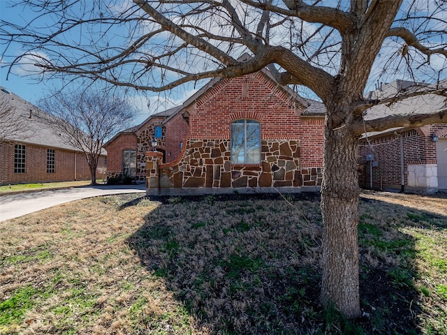 view of property exterior featuring stone siding and brick siding