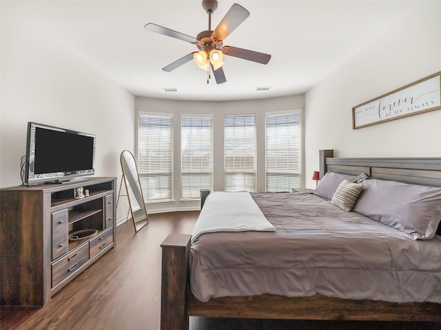 bedroom with ceiling fan, visible vents, and wood finished floors