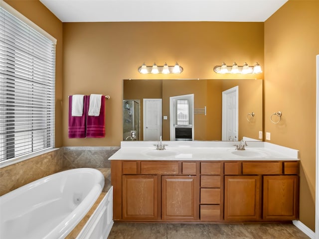 bathroom with a stall shower, plenty of natural light, a sink, and a bath