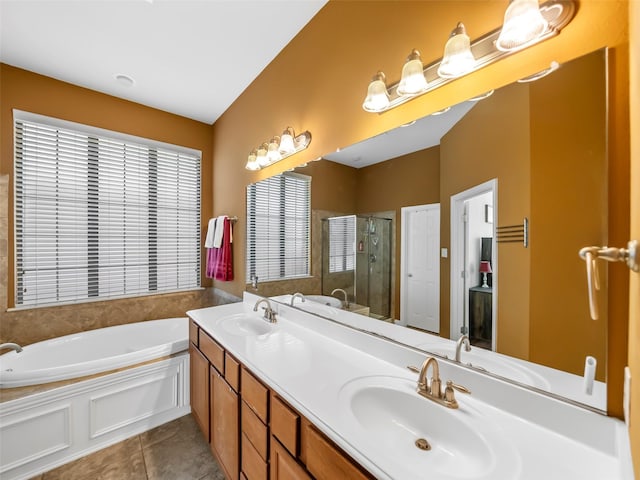 full bath with a bath, tile patterned flooring, a sink, and a shower stall