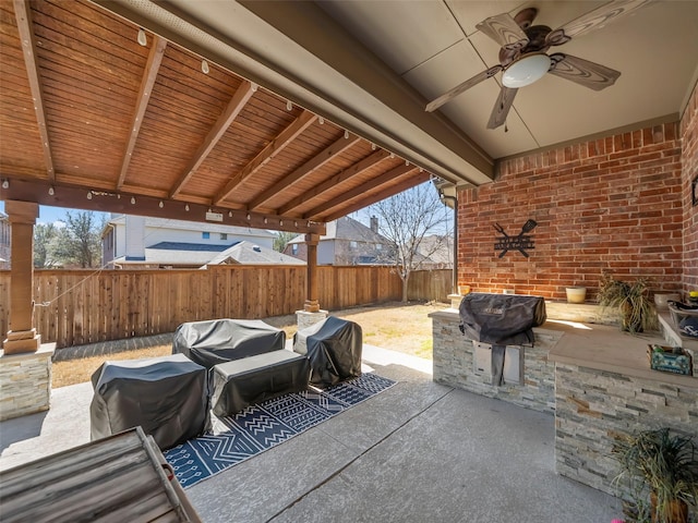 view of patio featuring ceiling fan, exterior kitchen, a fenced backyard, and a grill