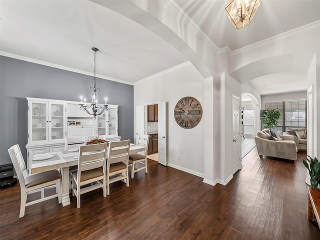 dining area featuring arched walkways, crown molding, dark wood finished floors, and a notable chandelier