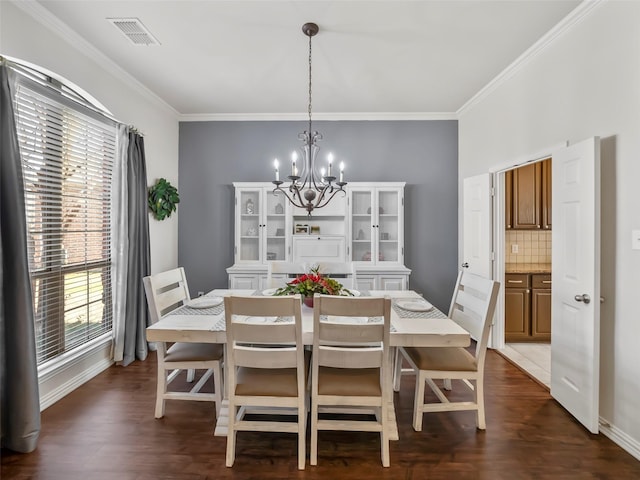 dining room with crown molding, dark wood-style flooring, plenty of natural light, and an inviting chandelier