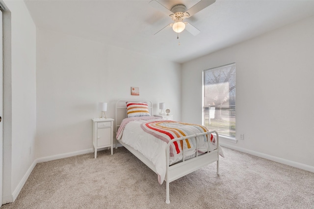 bedroom featuring light carpet, a ceiling fan, and baseboards