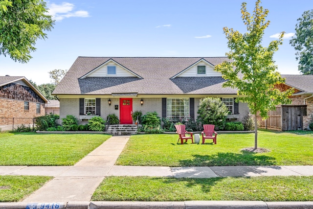 view of front of property featuring brick siding, a front lawn, and fence