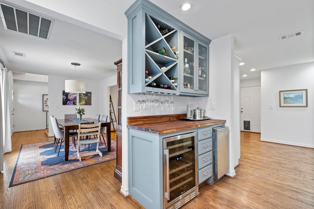 bar featuring a dry bar, light wood-style floors, wine cooler, and visible vents